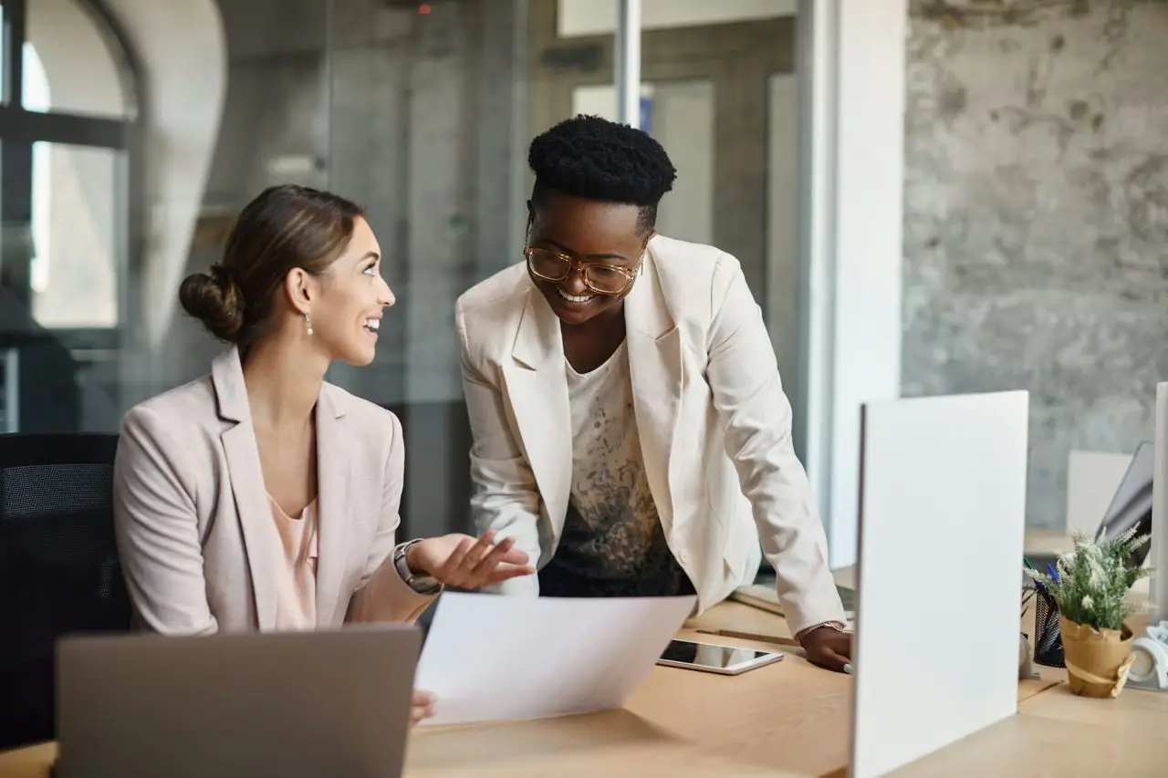 happy-businesswomen-talking-while-analyzing-plans-and-working-in-the-office-